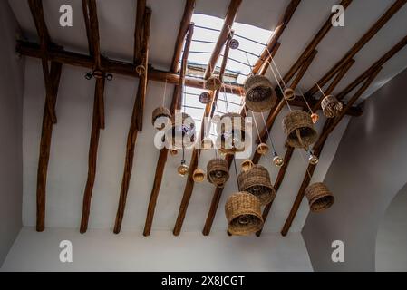 chandeliers made with wicker baskets hanging from the ceiling straw baskets hanging from the ceiling as chandeliers on wooden ceiling Stock Photo