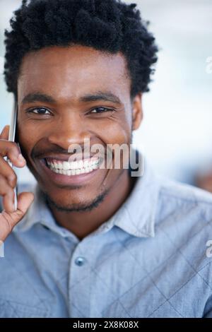 Happy black man, portrait and consulting with phone call for friendly discussion, chat or proposal at office. Young African or male person talking on Stock Photo