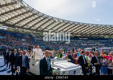 Rome, Italy. 25th May, 2024. Pope Francis waves as he arrives in the Pope Mobile at the Olympic Stadium. Pope Francis asked children, hailing from several countries around the globe, to pray for their peers suffering from war and injustice and encouraged them to continue dreaming of a better future. Credit: SOPA Images Limited/Alamy Live News Stock Photo