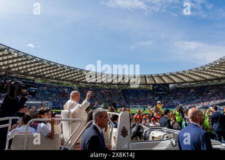 Rome, Italy. 25th May, 2024. Pope Francis waves as he arrives in the Pope Mobile at the Olympic Stadium. Pope Francis asked children, hailing from several countries around the globe, to pray for their peers suffering from war and injustice and encouraged them to continue dreaming of a better future. Credit: SOPA Images Limited/Alamy Live News Stock Photo