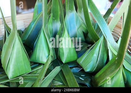 Khanom Sai Sai, Thai Dessert Made of Rice Flour with Sweetened Shred Coconut Filling Wrapped in Banana Leaf Before Steam Stock Photo