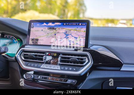 Close-up view of the navigation panel displaying the route of the BMW iX3m electric car while driving on the highway. Stock Photo