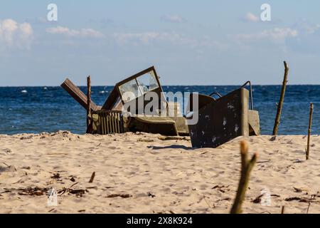 Historical reenactment. Background. Crashed, ruined American military vehicle Jeep Willys on the beach. Hel,  Baltic sea, Pomerania. Poland Stock Photo