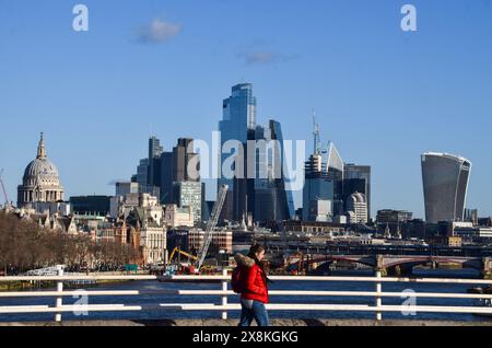 London, UK. 15th January 2024. A woman walks along Waterloo Bridge past the City of London skyline, the capital's financial district, on a clear day. Credit: Vuk Valcic/Alamy Stock Photo