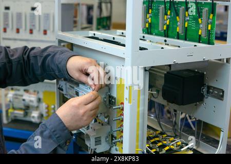 Perm, Russia - May 23, 2024: worker assembling electrical equipment in a factory Stock Photo