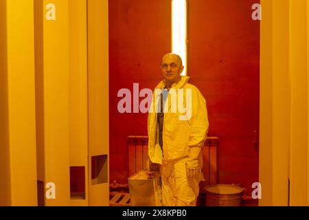 Perm, Russia - May 23, 2024: male worker in an industrial paint spray booth Stock Photo