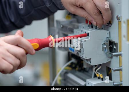 Perm, Russia - May 23, 2024: worker assembling electrical equipment in a factory Stock Photo