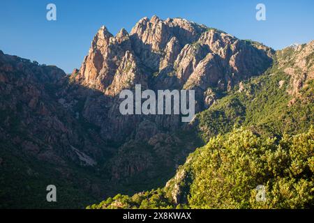 Evisa, Corse-du-Sud, Corsica, France. View from hillside across the Spelunca Gorge to the high granite cliffs of Capo Ferolata. Stock Photo