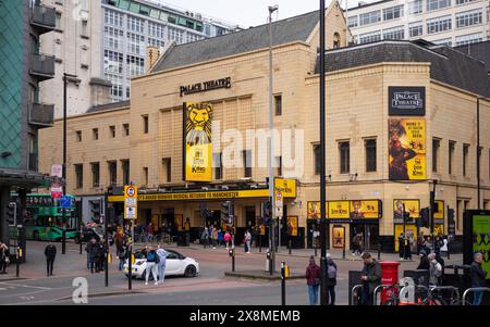 Manchester UK 26 March 2024. Busy urban scene outside Palace Theatre showcasing 'The Lion King' musical with yellow posters and bustling pedestrians Stock Photo