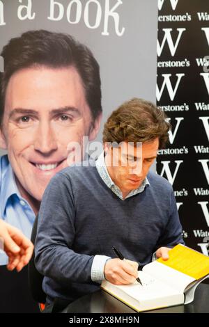 ROB BRYDON, BOOK SIGNING, 2011: Welsh actor and comedian Rob Brydon speed signing copies of his book 'Small Man In A Book' after all the meets and greets have been done at Waterstones in Birmingham, England on 30 October 2011. Photo: Rob Watkins.   INFO: Rob Brydon is a Welsh actor, comedian, and television presenter, renowned for his work in 'Gavin & Stacey' and 'The Trip' series. Known for his sharp wit and versatile voice work, he has become a beloved figure in British entertainment. Stock Photo