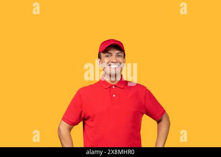 Smiling Man in Red Uniform and Cap Against Yellow Background Stock Photo
