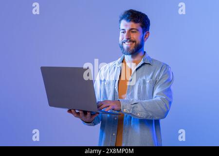 Man Smiles While Using Laptop Computer, Websurfing Stock Photo