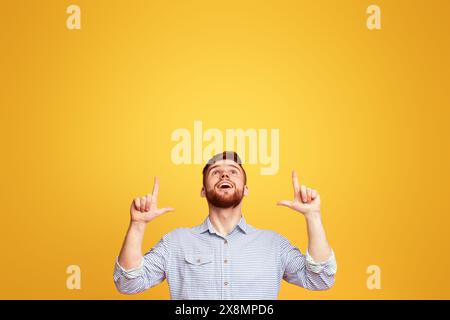 Man Raises Hands in Front of Yellow Background Stock Photo