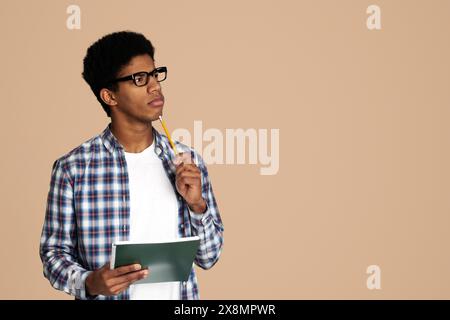 African-American Thoughtful Nerd Thinking about Test in Studio Stock Photo