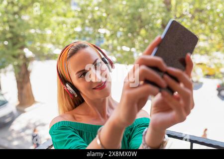 A woman is taking a selfie with her cell phone Stock Photo
