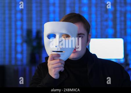 Hacker with mask in dark room, closeup Stock Photo