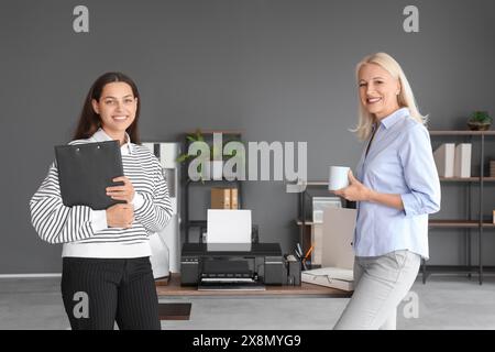 Female colleagues near printer in office Stock Photo