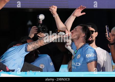 Manchester City's Jack Grealish (centre) takes a drink from Kyle Walker during a trophy parade in Manchester, after they won their fourth successive Premier League title and their sixth in seven years. Picture date: Sunday May 26, 2024. Stock Photo