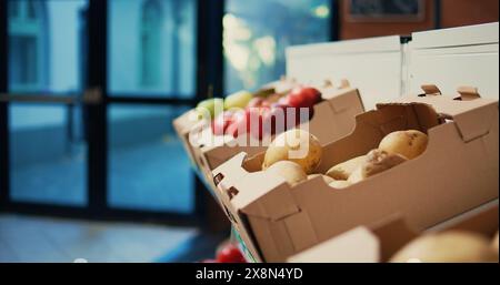 Eco friendly homegrown produce in crates on store shelves. Nonpolluting ethically sourced food alternatives to support sustainable lifestyle and healthy eating. Handheld shot. Close up. Stock Photo