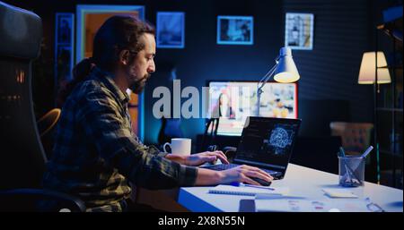 Data scientist updating artificial intelligence neural networks, writing complex binary code scripts. Teleworking freelancer in apartment office uses digital device programming to upgrade AI, camera B Stock Photo