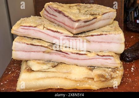 Detailed image of three slices of cured bacon stacked, showing the alternating layers of meat and fat. Perfect for representing high-quality ingredien Stock Photo