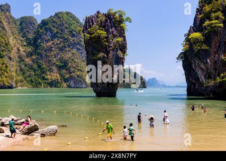PHANG NGA, THAILAND - MARCH 31 2023: Tourists exploring the beach and limestone formation of Ko Tapu (James Bond Island) in Phang Nga Bay Stock Photo