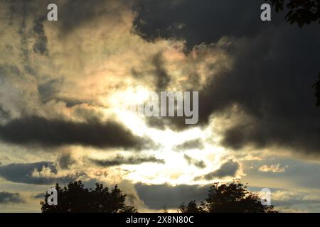 the strong sun shines through the clouds Stock Photo