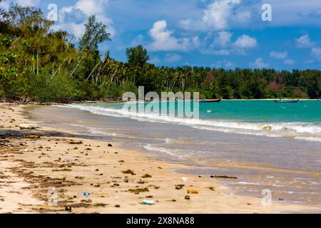 Plastic bottles and other pollution washed up onto a tropical beach by the tide  in asia Stock Photo