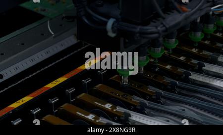 Close up of details of automatic SMD pick and place machine during work. Creative. Assembly of computer printed circuit board at factory. Stock Photo