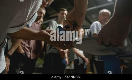 Woodworking master class. Creative. Close-up of man shows group of people how to take measurements on wooden board. Master class in carpentry in Stock Photo