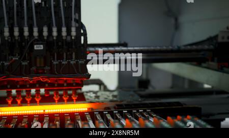 Factory machine at work: printed circuit board being assembled with automated mechanism. Creative. Technological background with modern equipment. Stock Photo