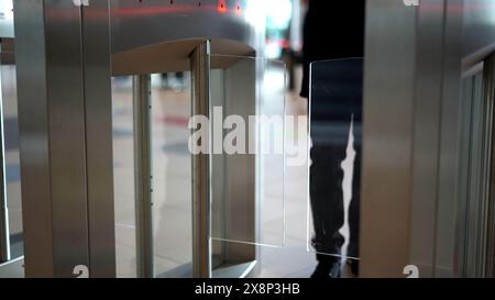 Businessman entering office building trough security gates. Media. Man passing through the turnstile. Stock Photo