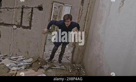 Amateur video shot of man trying to survive in damaged brick house. Stock clip. Remains of ruined house. Causes of war. Stock Photo