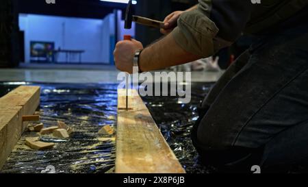 Close up of worker using tools for making holes in wooden beam. Media. Carpentry works for making decorations. Stock Photo