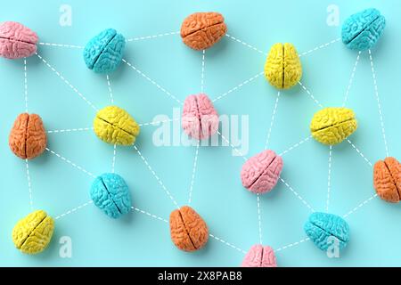 Teamwork and network of ideas. Exchange of ideas, brainstorming and collaboration. Colorful human brains connected by lines on blue background. 3D ren Stock Photo