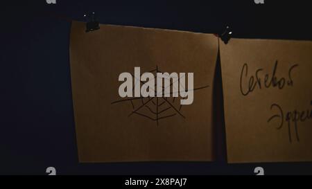Mysterious notes on strings. Stock footage. Notes with encrypted signs in night room. Lantern lighting mysterious notes in night office Stock Photo