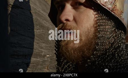 Medieval old knight helmet and chain mail for protection in battle. Media. Close up side view of a man in very heavy headdress, middle ages armor Stock Photo
