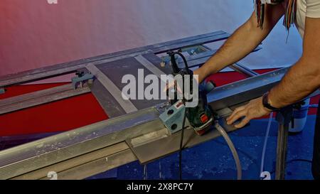 Close up of cutting narrow tiles of ceramic panel with circular saw and water. Creative. Industrial background with using of professional equipment. Stock Photo