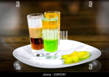 Whiskey-cola cocktail, mojito-cocktail, orange cocktail, strawberry cocktail in glass glasses with straws. Bar accessories on a wooden stand Stock Photo