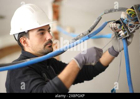 Electrician checking electrical installation using screwdriver in a house under renovation Stock Photo