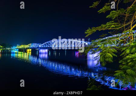 Hue, Vietnam - April 10th, 2024: Panoramic view of Truong Tien Bridge in Hue City at night. Bridge illuminated all over with blurry reflection Stock Photo