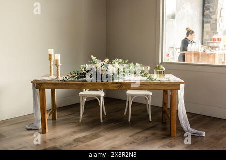 Wooden table with floral centerpiece and candles Stock Photo