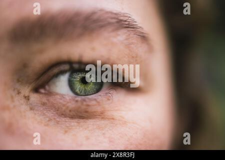 Close-up of a green eye with freckles and detailed features Stock Photo