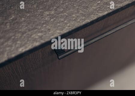 Close-up of modern cabinet handle on textured countertop Stock Photo