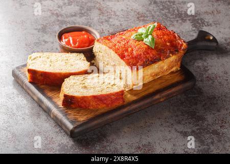 Healthy and comforting meal chicken meatloaf served with ketchup closeup on the wooden board on the table. Horizontal Stock Photo