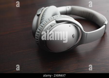 Stylish silver headphones on a wooden table Stock Photo