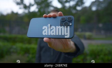 UK, London - September 15, 2023: Man takes pictures on new iPhone. Action. Apple's logo on new iPhone 15 pro. Shooting on new iPhone 15 pro in nature Stock Photo