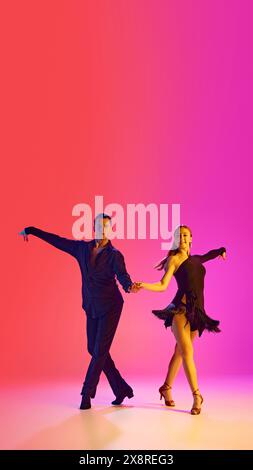 Poster. Young ballroom dancers practicing dance moves in stages costumes in neon lighting against gradient background. Stock Photo