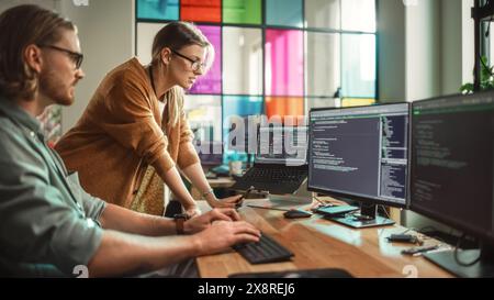 Male Data Scientist and Female Developer Working With Errors in Code on Desktop Computer in Creative Office. Caucasian Man and Woman Succesfully Fixed a Software Bug And High Five Each Other. Stock Photo
