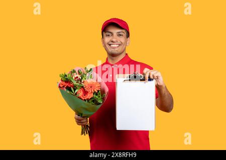 Smiling Delivery Man Holding Flower Bouquet and Clipboard Indoors Stock Photo